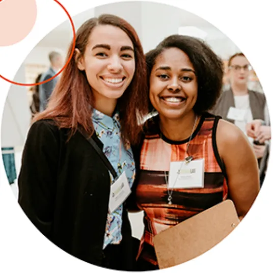 Two smiling BrandLab students at an event