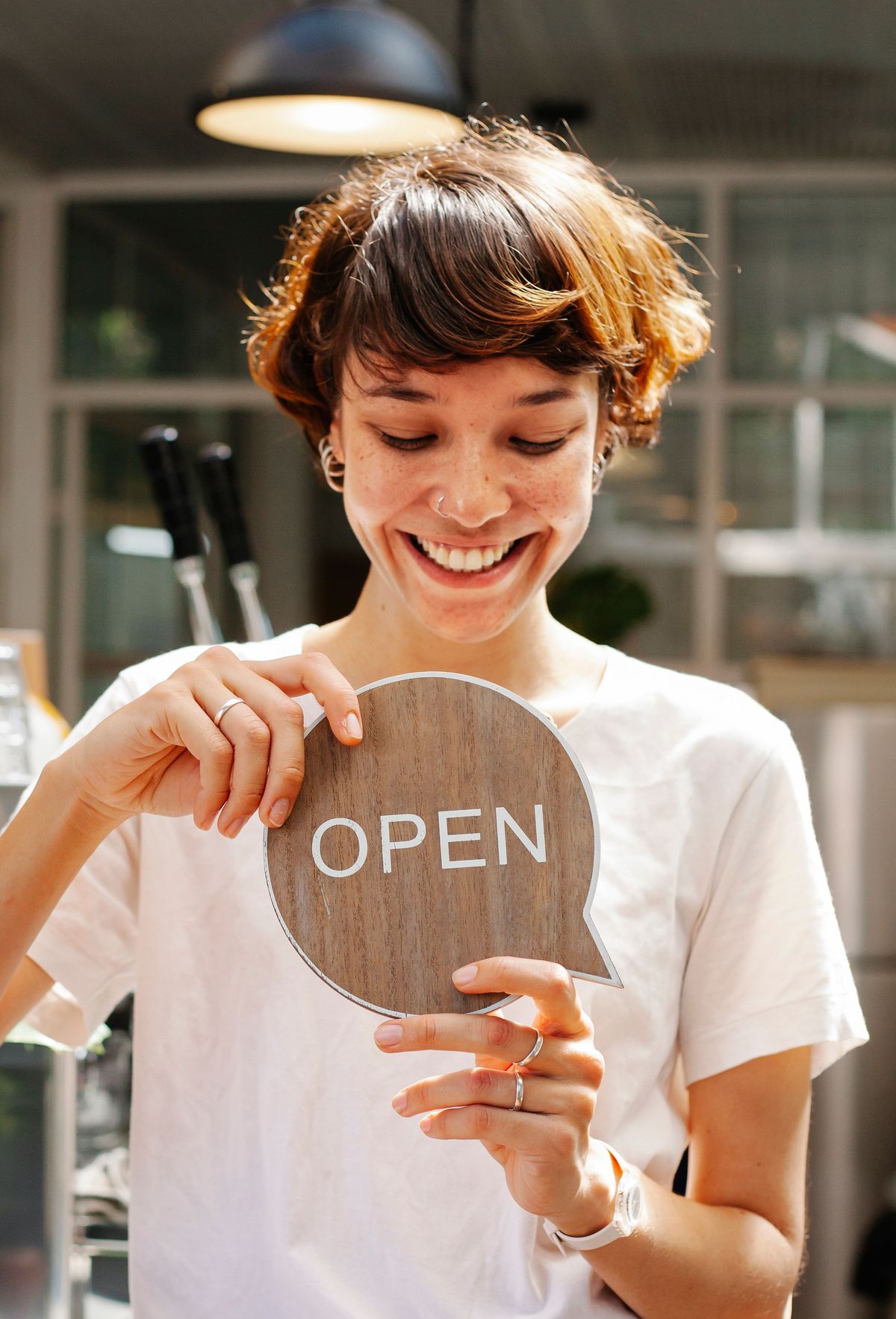 Small business owner holding an open sign